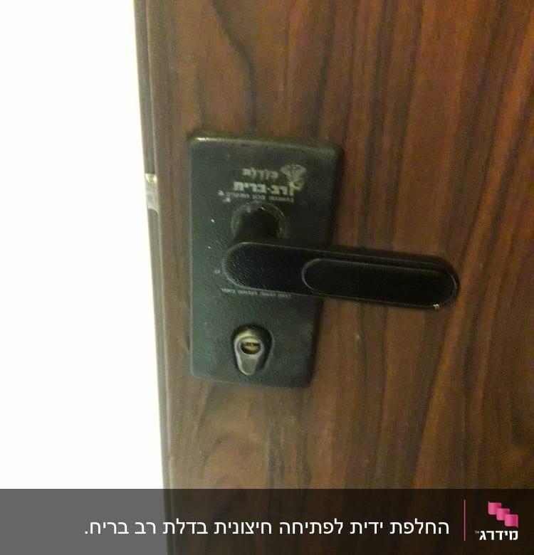 מנעול דלת עם ידית שחורה על דלת עץ
